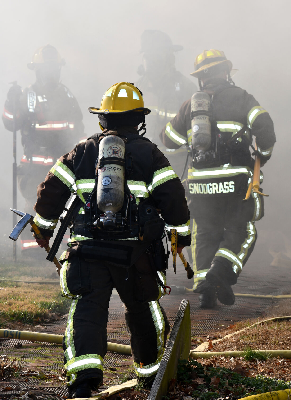 Firefighters walk toward the home one fire